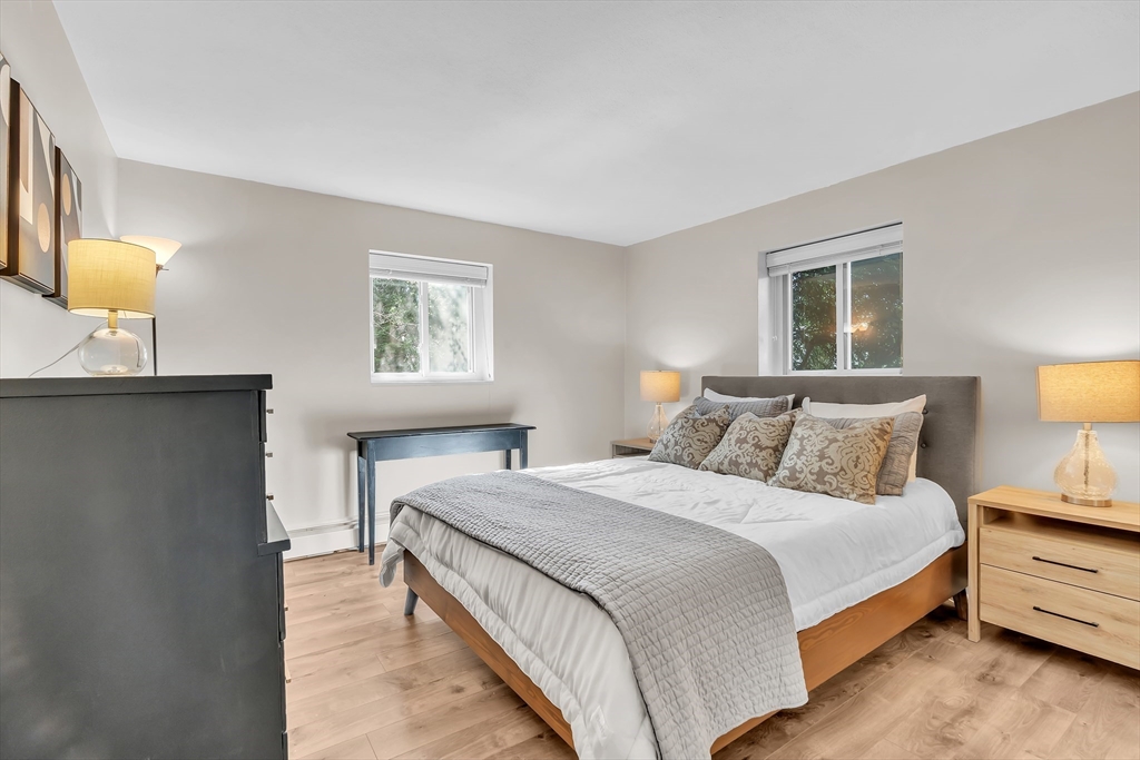 22 Bryon Road, Unit 1 Boston, MA 02467 - Photo 9 of 19 a bedroom with a bed and lamps