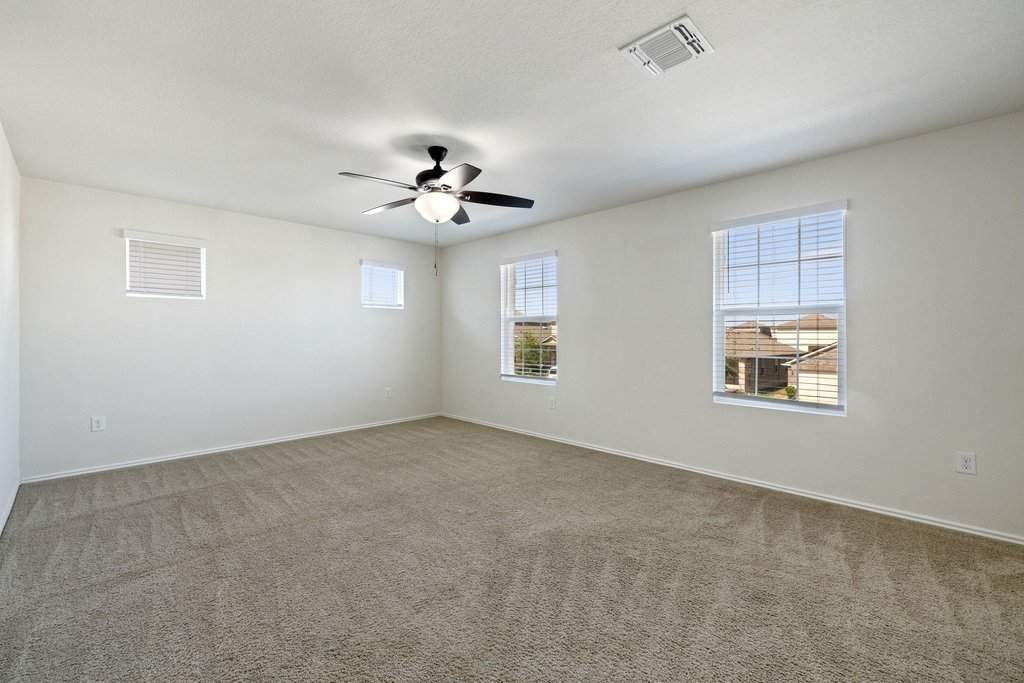 15011 Tuff Rd Manor Manor, TX 78653 - Photo 20 of 37 Large upstairs game room or flex space with four windows, a ceiling fan, and plenty of room for a playroom, media room, or home office.
