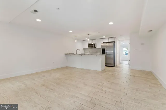 a view of a kitchen with a sink and a refrigerator