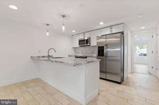 a kitchen with stainless steel appliances a refrigerator sink and microwave