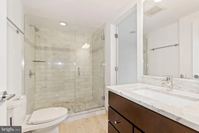 a bathroom with a sink a toilet and shower