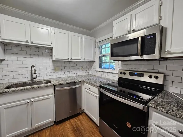 a kitchen with cabinets stainless steel appliances a sink and a microwave