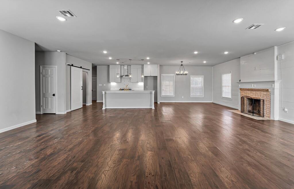 2001 Colcord Avenue Waco, TX 76707 - Photo 2 of 27 a view of a kitchen and an empty room with wooden floor