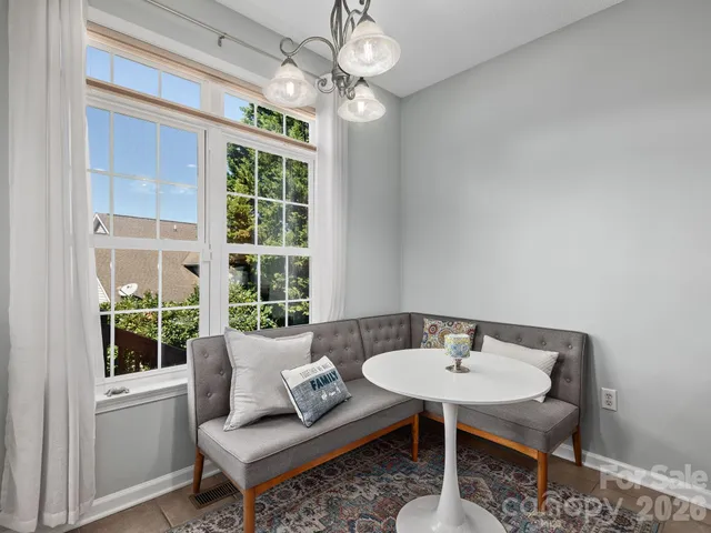 a living room with furniture a chandelier and a window