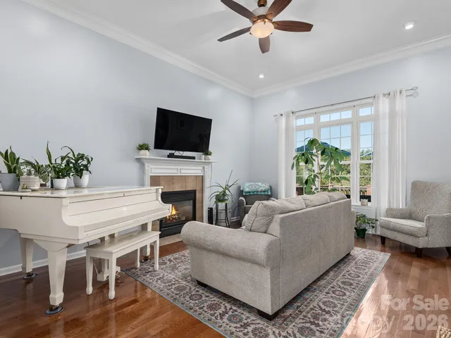 a living room with furniture a flat screen tv and a large window