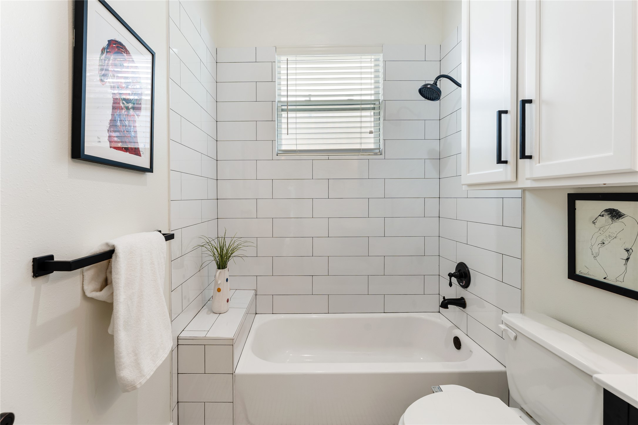 415 West 8th Street Houston, TX 77007 - Photo 35 of 39 Classic materials meet contemporary design in this beautifully remodeled bathroom. A full tub and shower combination, custom cabinetry, and elevated finishes provide both comfort and everyday convenience. The cohesive design complements the home's modern aesthetic while offering lasting appeal.