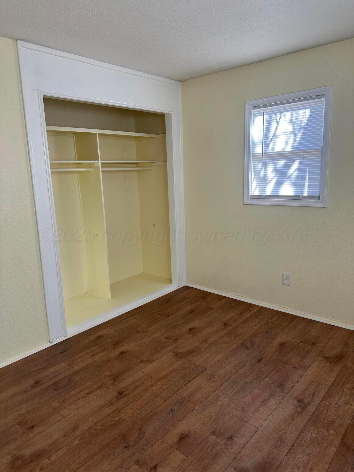 1012 Harper Street Amarillo, TX 79107 - Photo 11 of 24 a view of an empty room with wooden floor and a window