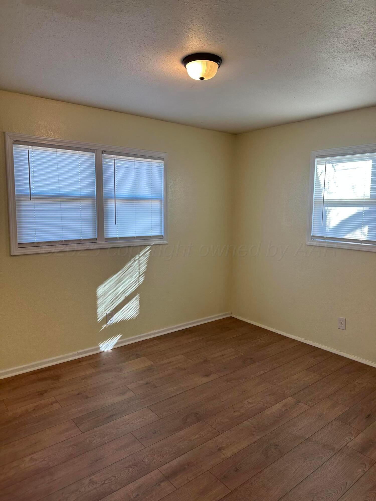 1012 Harper Street Amarillo, TX 79107 - Photo 12 of 24 an empty room with wooden floor and windows