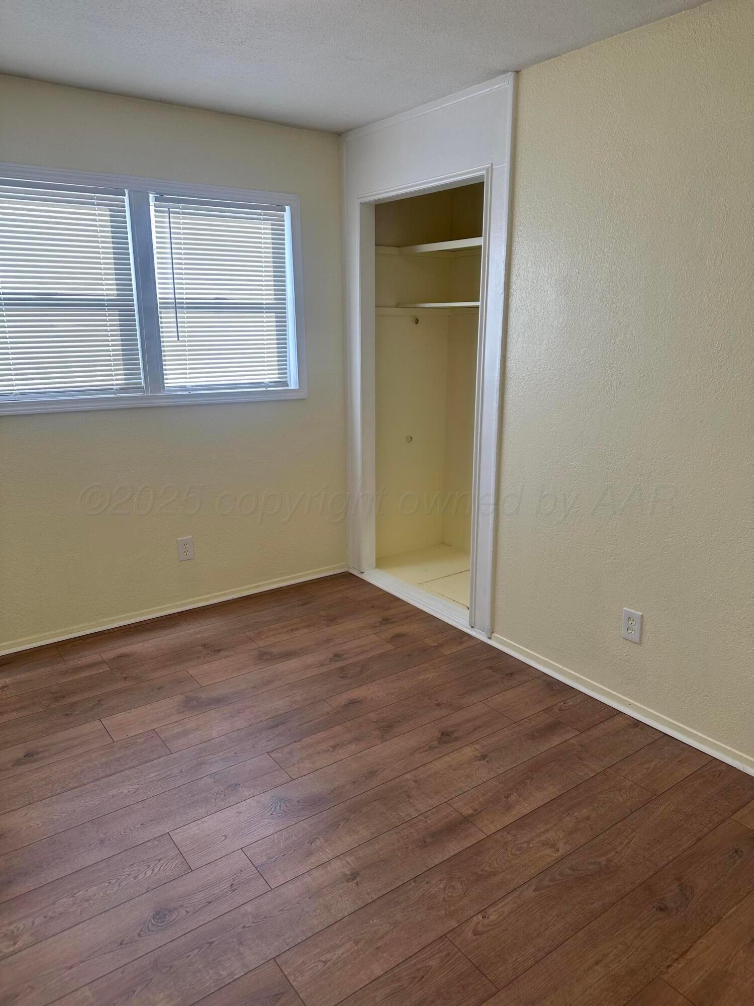 1012 Harper Street Amarillo, TX 79107 - Photo 14 of 24 a view of an empty room with wooden floor and a window