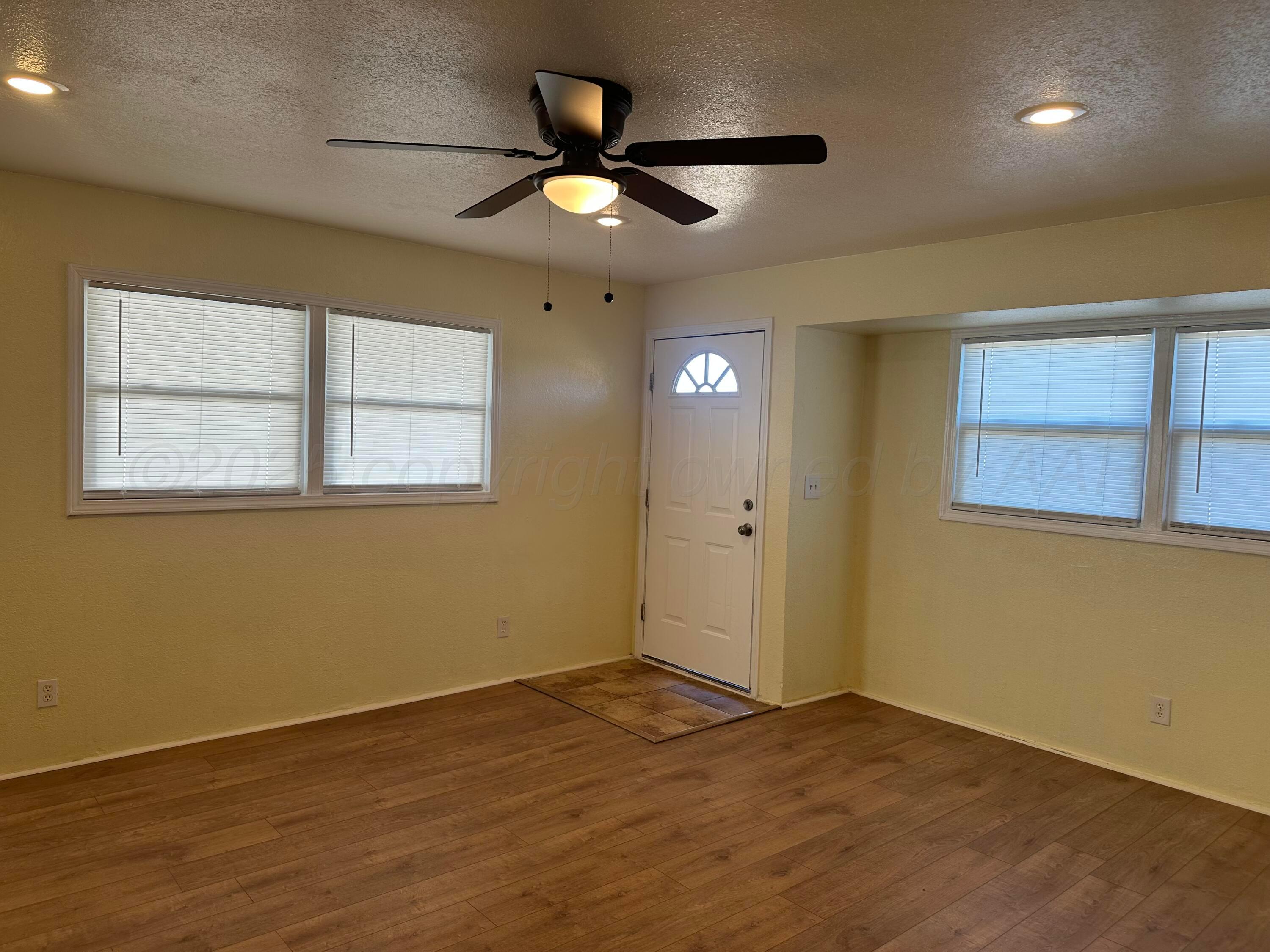 1012 Harper Street Amarillo, TX 79107 - Photo 4 of 24 a view of an empty room with wooden floor and a window