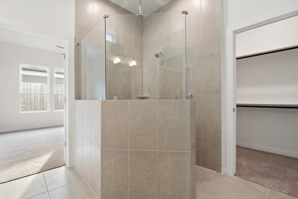 2205 Cento Walk Round Rock, TX 78664 - Photo 15 of 35 Full bath with carpet flooring, a walk in shower, tile patterned flooring, and a walk in closet