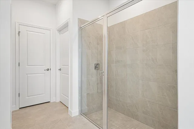 a bathroom with a shower and a glass door
