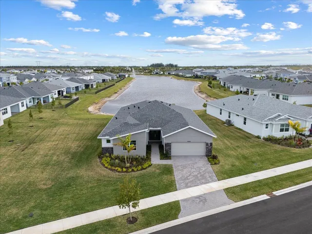 an aerial view of a house with a garden and lake view