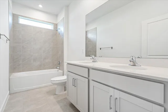 a bathroom with a double vanity sink toilet and shower