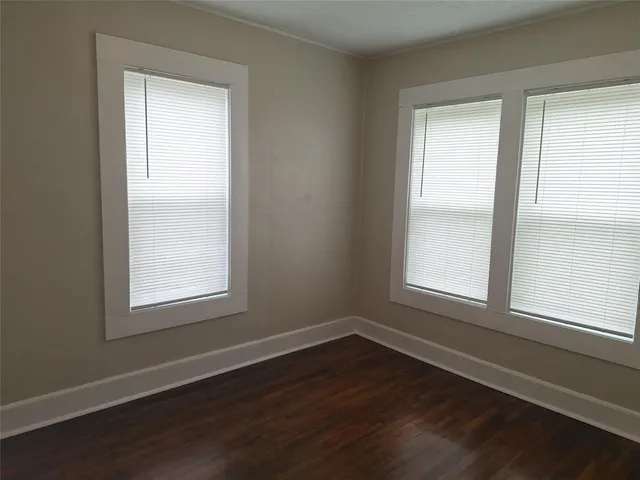 an empty room with wooden floor and a window