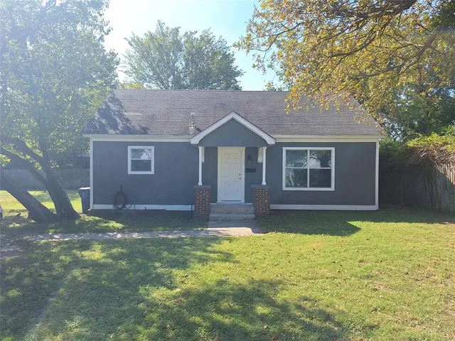 a front view of a house with yard and green space