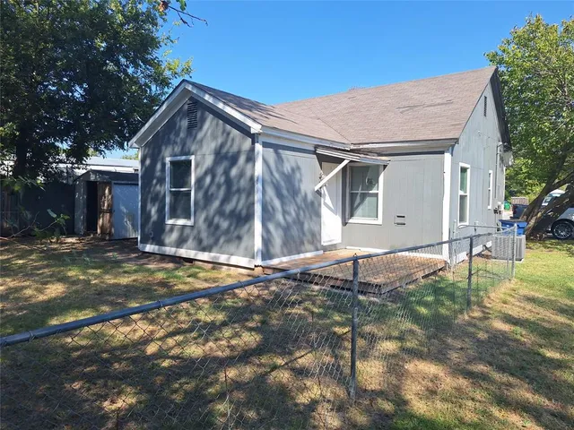 a backyard of a house with table and chairs
