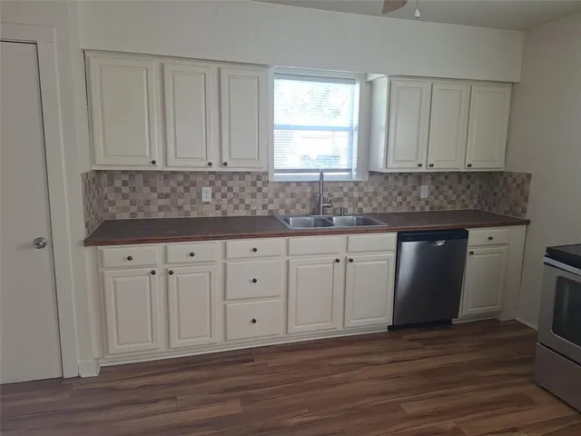 a kitchen with granite countertop white cabinets and a sink