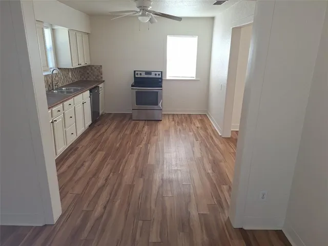 a kitchen with wooden floors and sink