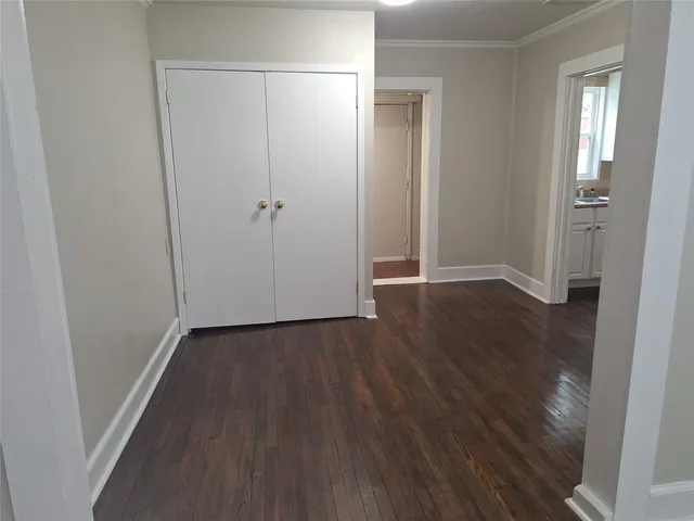 an empty room with wooden floor and closet