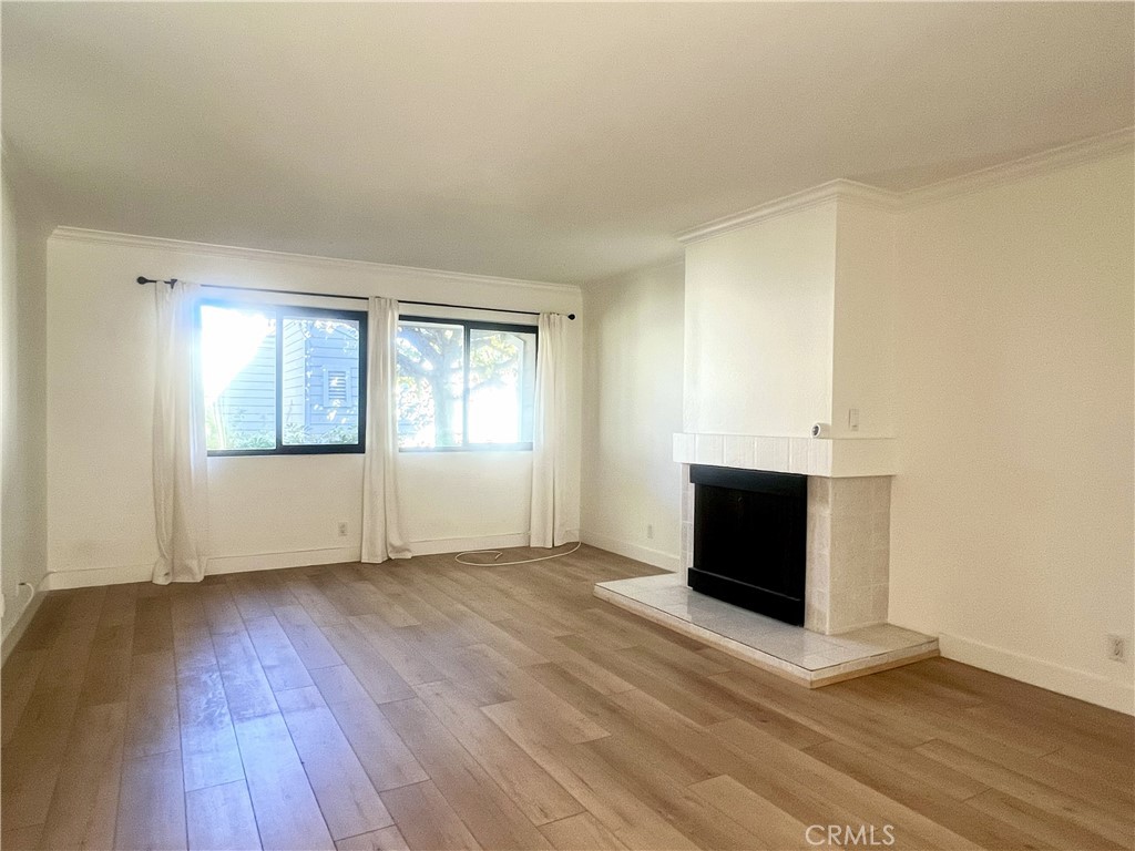 4 Latitude Court Newport Beach, CA 92663 - Photo 13 of 41 an empty room with wooden floor fireplace and windows