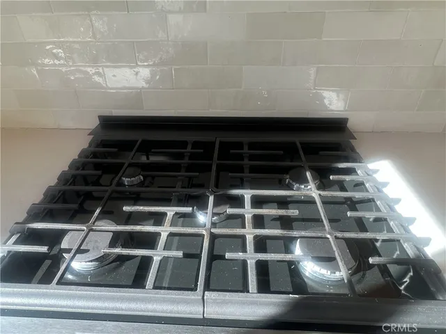 a view of an empty room with wooden floor and a fireplace