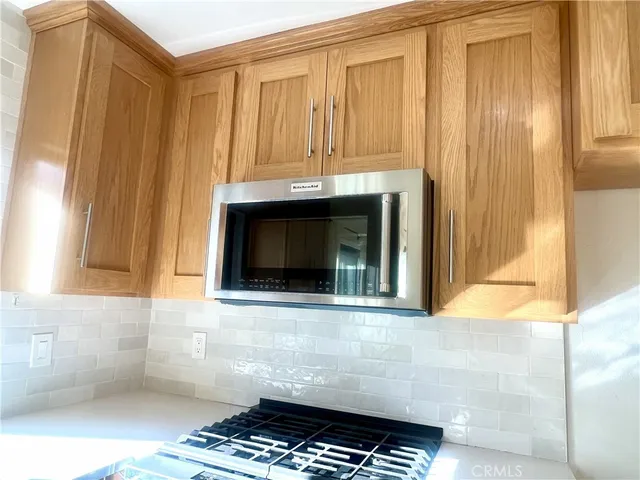 an empty room with wooden floor fireplace and windows