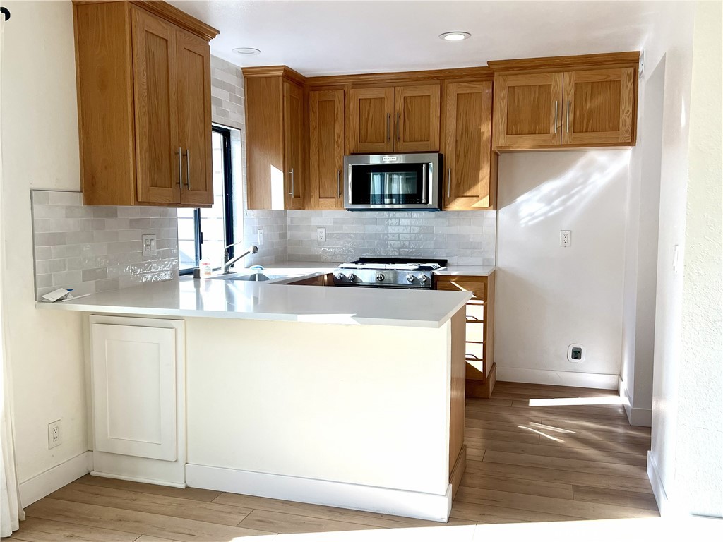 4 Latitude Court Newport Beach, CA 92663 - Photo 7 of 41 a kitchen with stainless steel appliances granite countertop a sink and a stove top oven