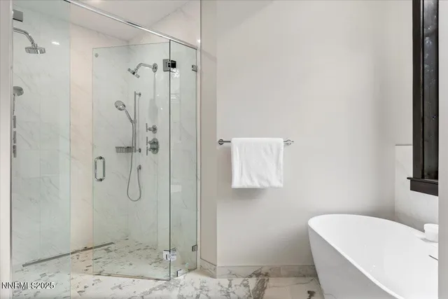 a bathroom with a tub a toilet and a shower