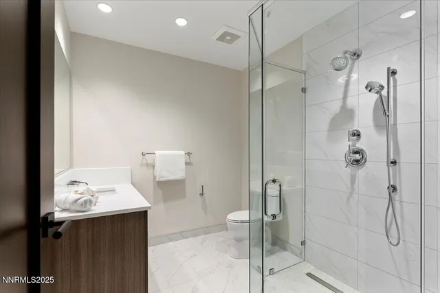 a bathroom with a sink a toilet and shower