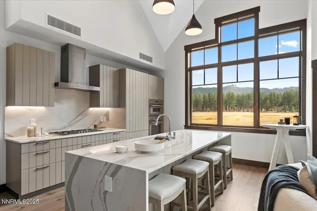 a dining hall with stainless steel appliances granite countertop a sink and a large window
