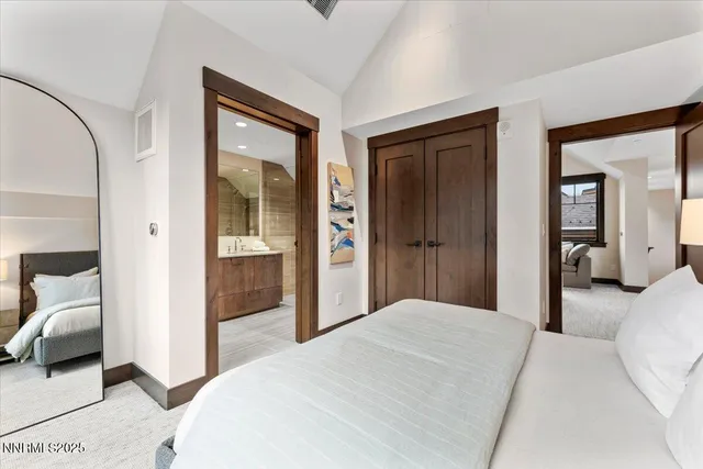 a bedroom with a bed and a large mirror