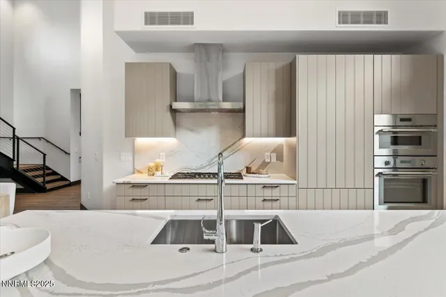 a kitchen with kitchen island stainless steel appliances a sink and a stove