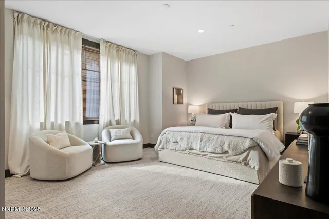 a spacious bedroom with a bed and glass window
