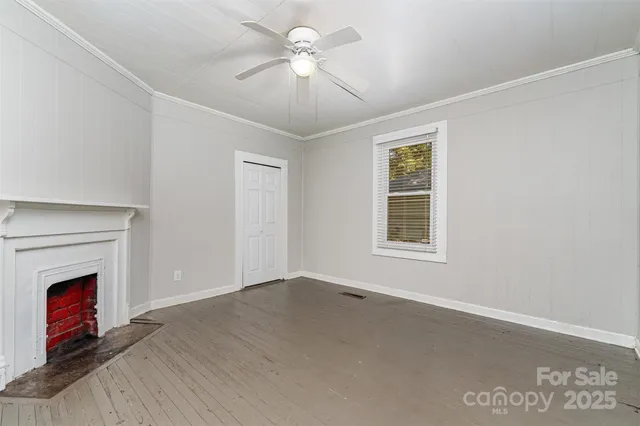 a view of empty room with a fireplace and fan