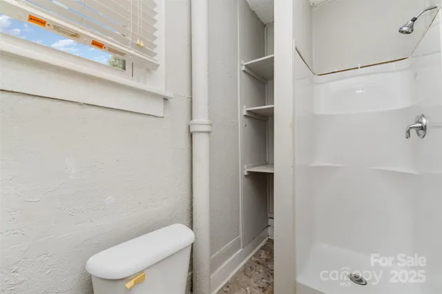 a bathroom with a toilet and a shower