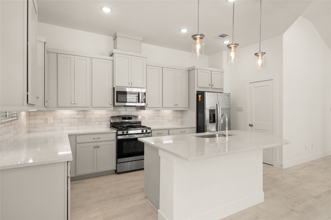 520 Red Cascade Trail Willis, TX 77318 - Photo 2 of 27 a kitchen with stainless steel appliances granite countertop a sink a stove a refrigerator and white cabinets
