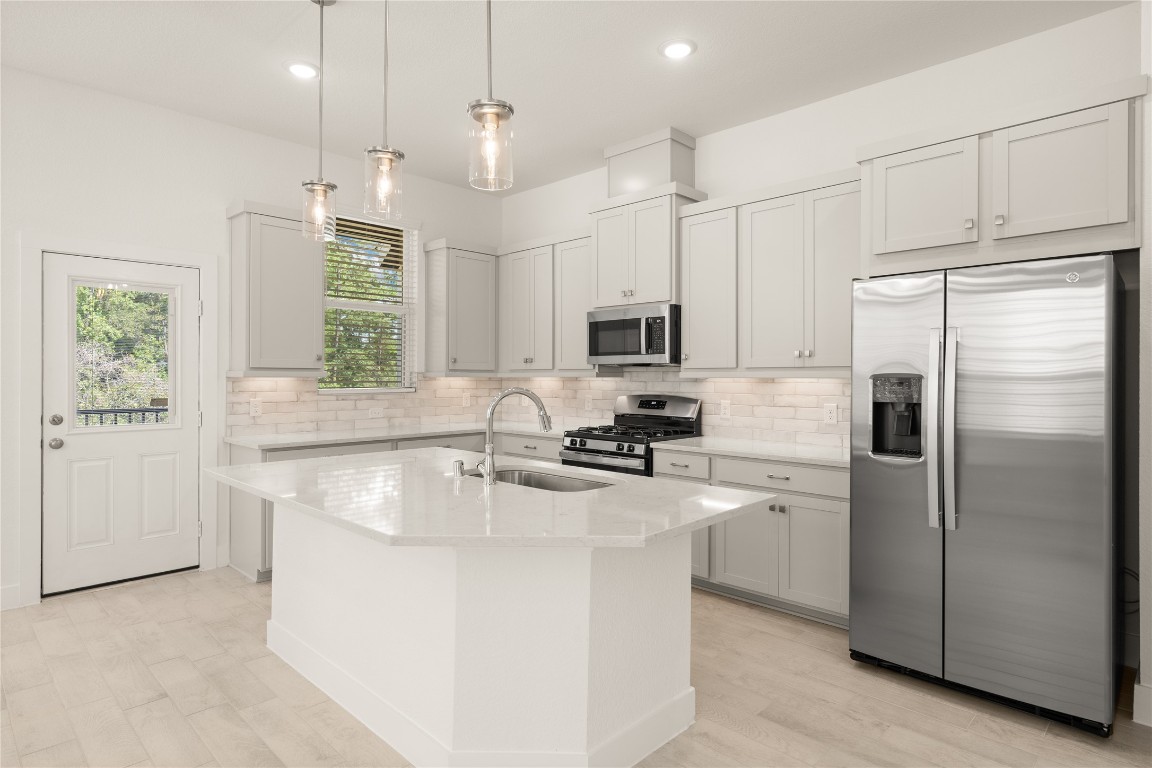 520 Red Cascade Trail Willis, TX 77318 - Photo 3 of 27 a kitchen with kitchen island white cabinets stainless steel appliances a sink and a window