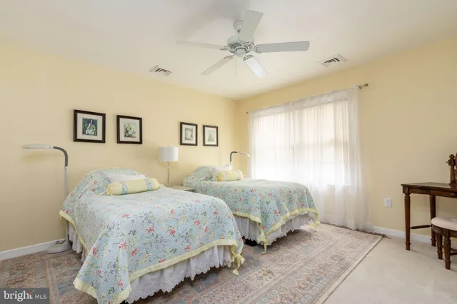 a bedroom with two beds and painting on the wall
