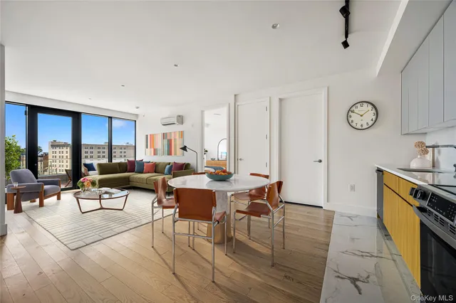 a living room with furniture a clock on wall and a window