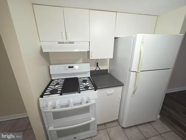a stove top oven sitting inside of a kitchen