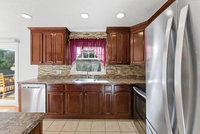 a kitchen with stainless steel appliances granite countertop a sink stove and refrigerator