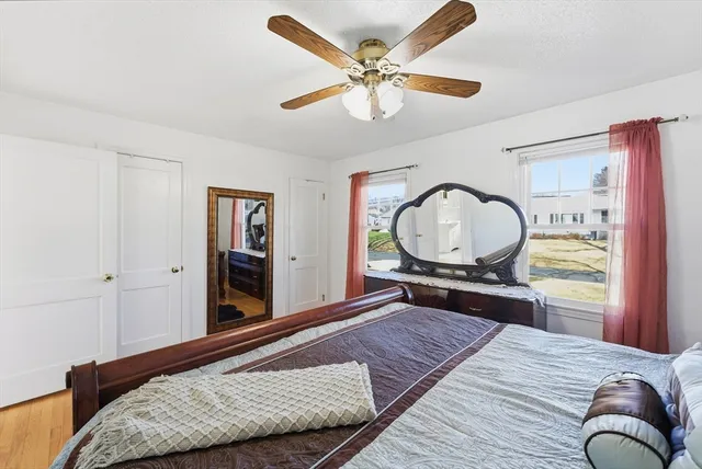 a bedroom with a bed and dresser with wooden floor