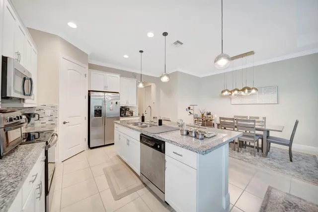 a kitchen with a sink a counter top space stainless steel appliances and cabinets