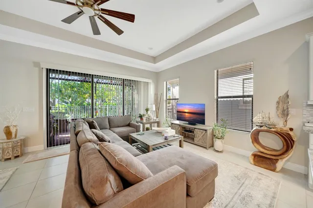 a living room with furniture a flat screen tv and a large window