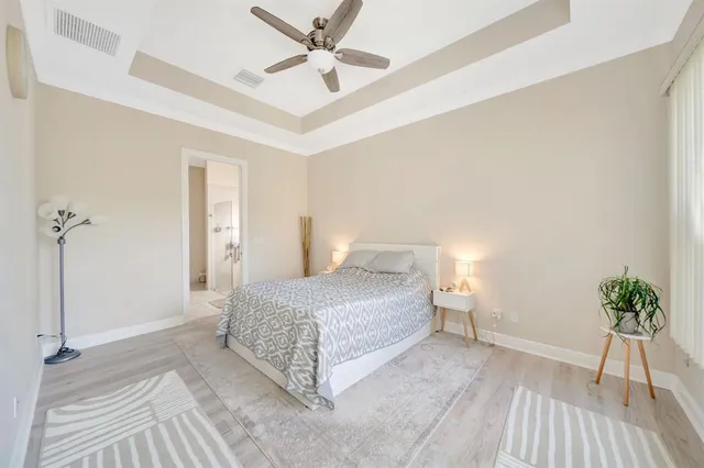 a spacious bedroom with a bed and a potted plant