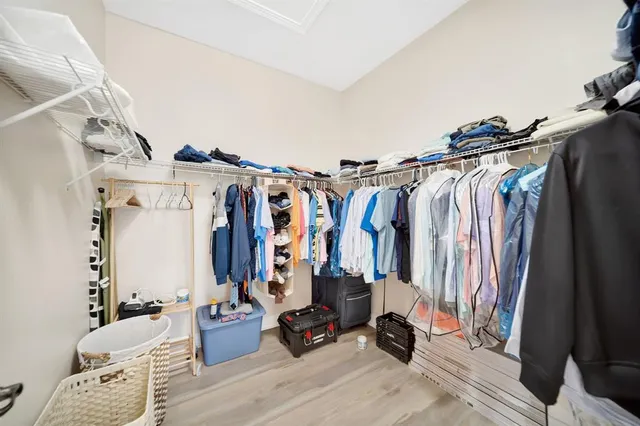 a view of walk in closet with clothes and shoes