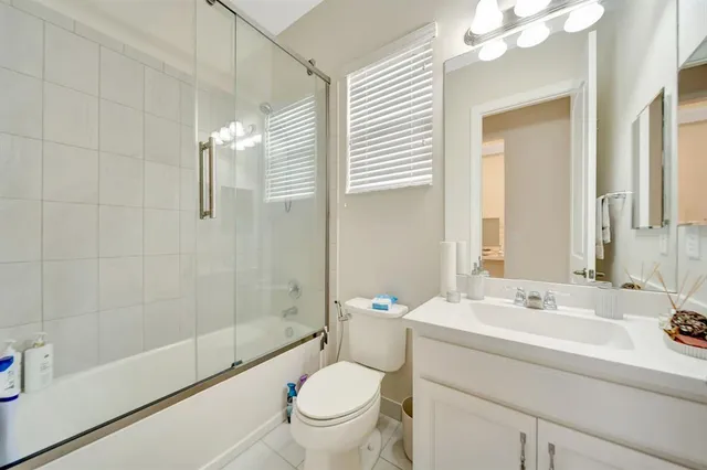a bathroom with a sink a toilet a mirror and shower