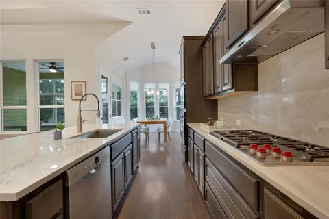 a kitchen with stainless steel appliances granite countertop a sink stove and cabinets