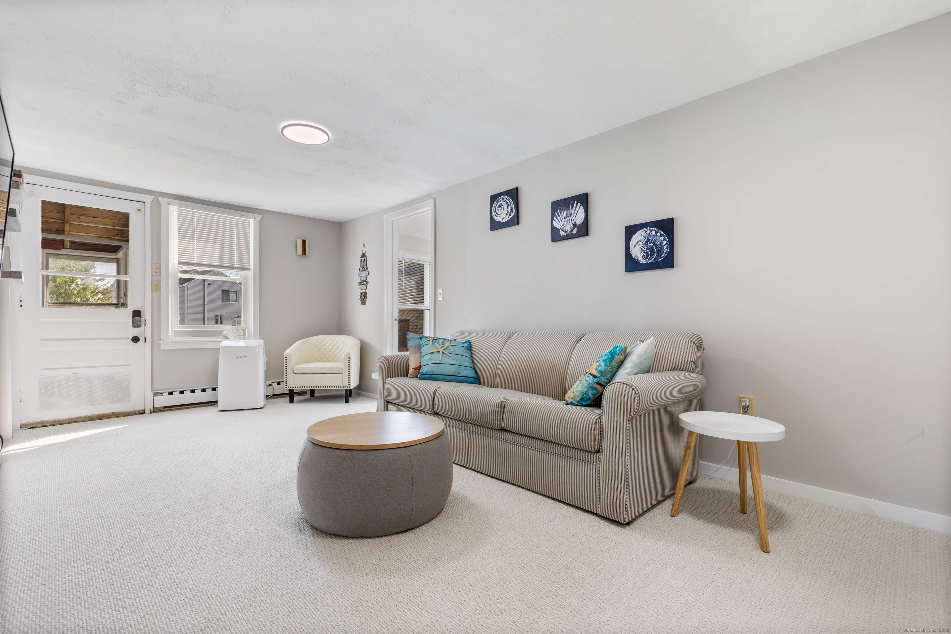 176 Shore Road, Unit B Clinton, CT 06413 - Photo 13 of 24 a living room with furniture a window and a table